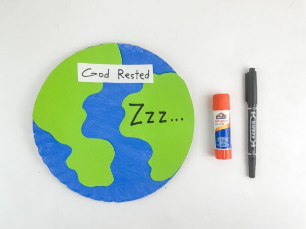 The completed paper plate Earth craft next to a glue stick and a black marker.