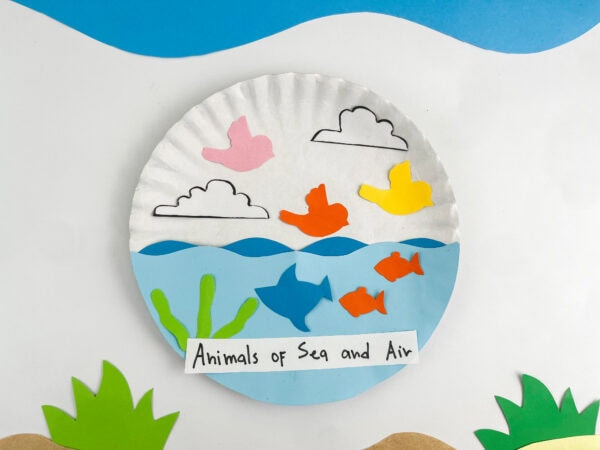 Close-up of a completed paper plate craft depicting birds flying in the sky above fish swimming in the sea.