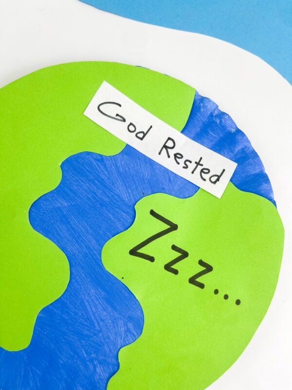 An angled, cropped close-up of the paper plate Earth craft showcasing the text details.