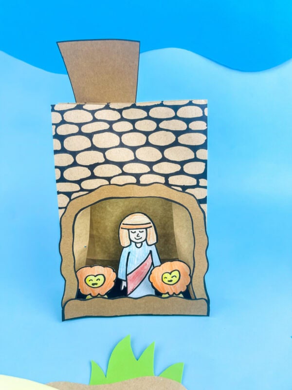 Finished craft on a blue background with grass and hill decorations.