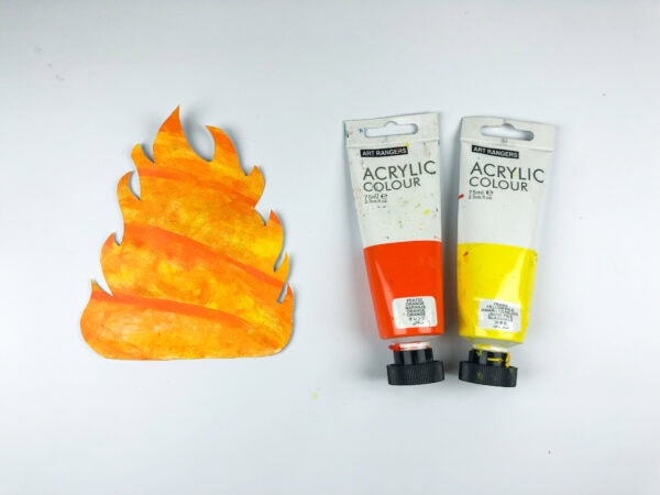 Painted fire cutout beside paint tubes