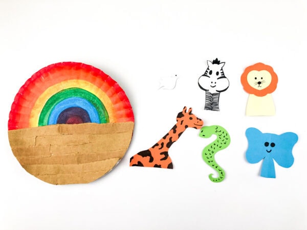 Rainbow-and-cardboard paper plate base next to finished animal cutouts (dove, zebra, lion, giraffe, snake, elephant).