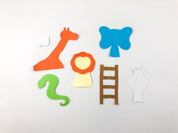 Assembled paper animal shapes: giraffe, elephant, lion, snake, dove, and ladder.