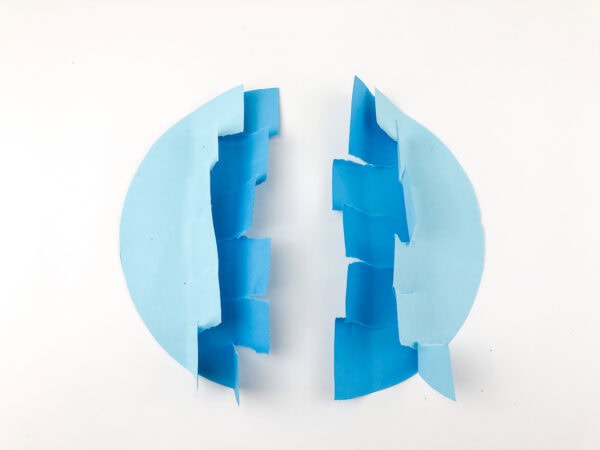 Two light blue half-circles with jagged, zigzag-cut blue edges facing each other.