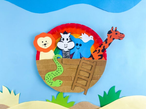 rainbow paper plate with glue stick and torn cardboard strips ready to make ark hull Noah's Ark craft