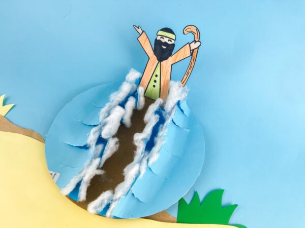 The completed diorama with the figure, parted water, sand, and grass, viewed at a slight angle.