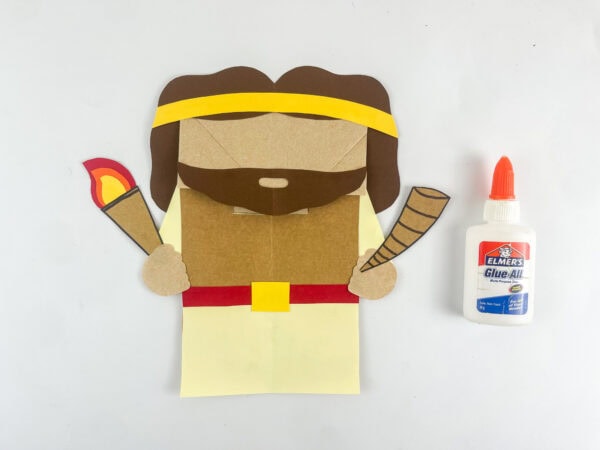 Gideon paper bag puppet with torch and horn attached to fist pieces before adding googly eyes

