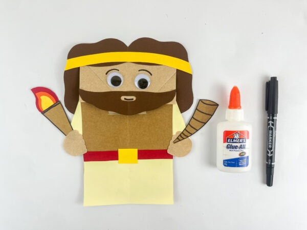 Gideon paper bag puppet with googly eyes eyebrows and smile drawn completed craft step

