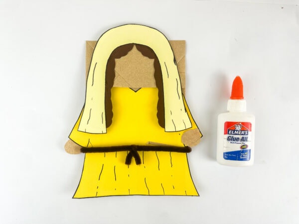 Deborah paper bag puppet with cream veil brown hair and belt assembled before adding googly eyes scroll and palm tree