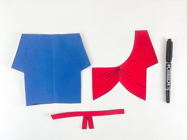 adding black marker fold and drape detail lines to Ezekiel robe and sash pieces for paper bag puppet craft
