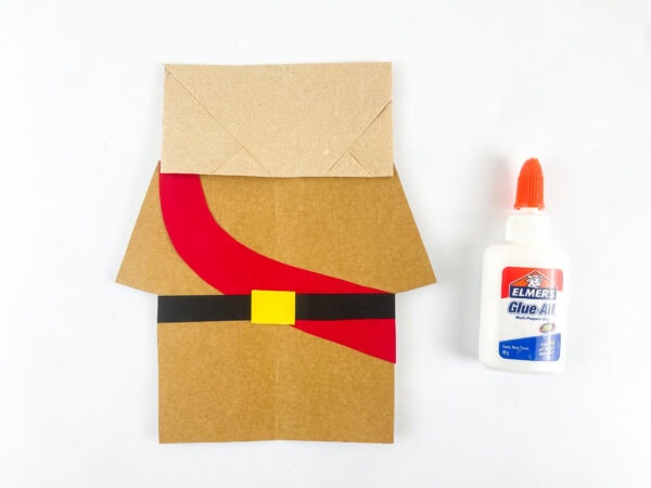 Gluing the Joshua puppet robe and belt onto the paper bag.