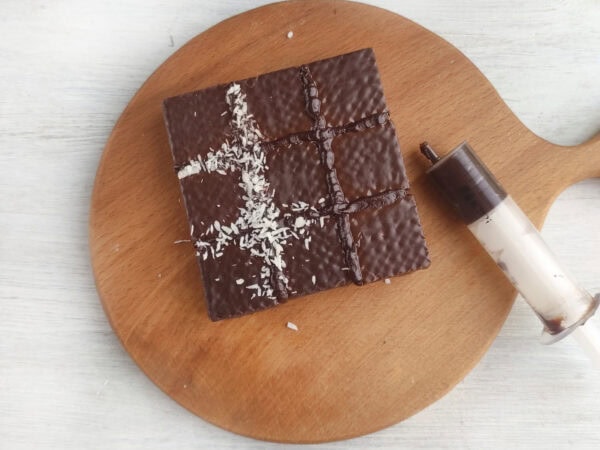 Chocolate wafer tic tac toe board with coconut grid lines.