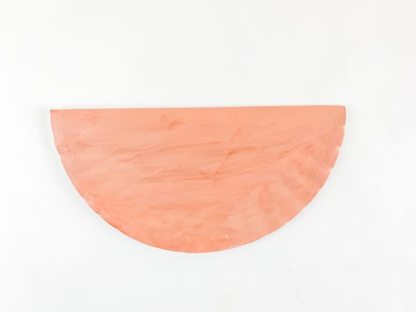 Painted paper plate folded in half to create a rocking base