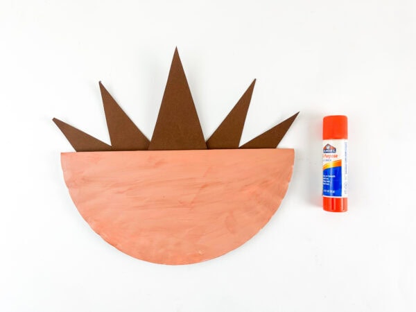 Gluing paper spines inside a folded paper plate