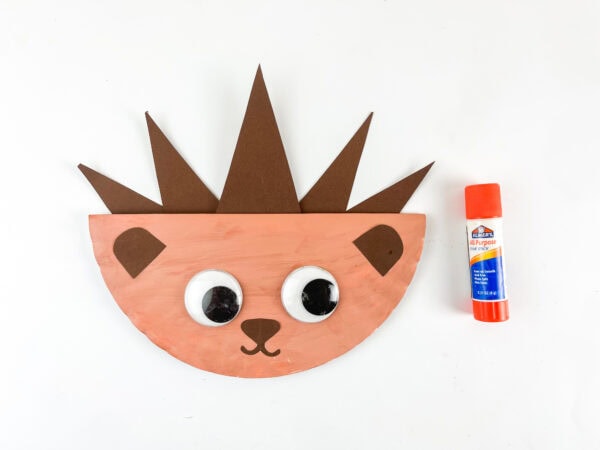 Adding large googly eyes to a paper plate hedgehog