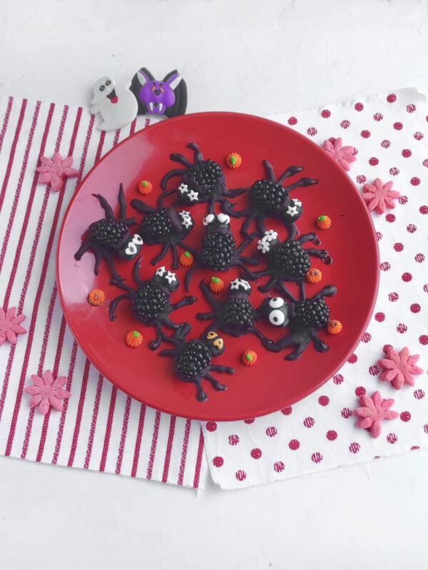 Halloween fruit spiders with candy decorations.