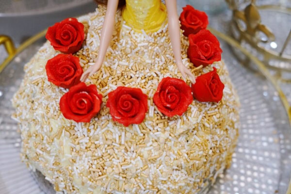 Red icing roses decorating a Princess Belle birthday cake