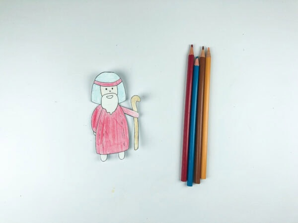 Colored Moses figure beside colored pencils